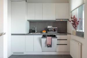 a white kitchen with a stove and a microwave at Platinum 1 in Gdynia