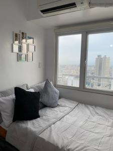 a bed in a room with two large windows at JC Condo, SMDC Green Malate Taft Manila in Manila