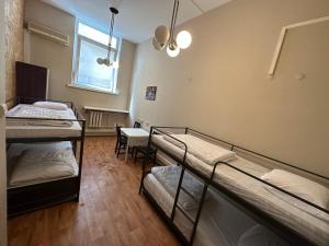a room with three bunk beds and a window at Pacific Hostel in Vilnius