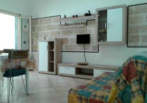 a living room with a tv and a desk and a couch at Casa Giovanni by My Home Apulia in Torre Lapillo