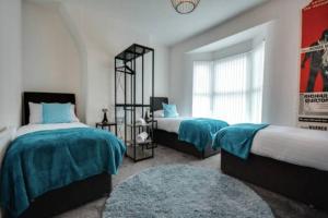 a bedroom with two beds and a window at Antonio str Liverpool 8 beds in Liverpool