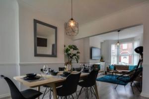 a dining room and living room with a table and chairs at Antonio str Liverpool 8 beds in Liverpool