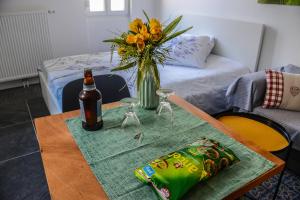 - une table avec une bouteille de vin et un vase de fleurs dans l'établissement "Urbaine Jardin" Charmant studio idéalement situé "Les Péri-Urbaines", à Riedisheim