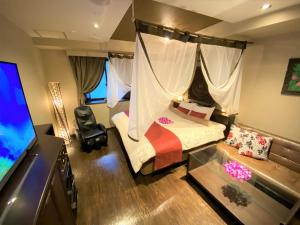 a bedroom with a canopy bed and a tv at Hotel Bali An Resort Nambadotonbori in Osaka