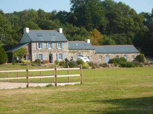 a large stone house with a fence in front of it at Gite équestre du Dourdu in Lopérec