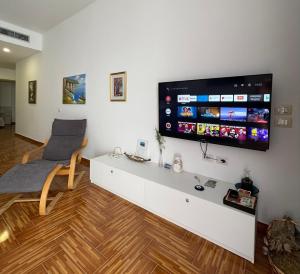 a living room with a flat screen tv on a wall at Port Side Sarande in Sarandë