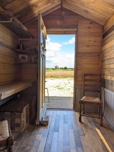 eine offene Tür zu einer Hütte mit Holzboden in der Unterkunft Shires Barns in Chippenham