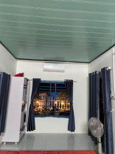 Zimmer mit einem Fenster und blauen Vorhängen in der Unterkunft phòng mùa thu in Tuy Hoa
