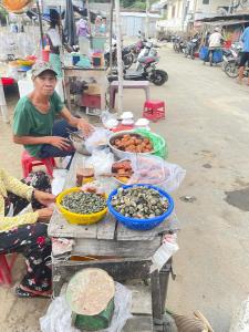 a man sitting next to a table with food on it at phòng mùa thu in Tuy Hoa