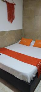 Dos camas en una habitación con toallas naranjas. en posada barrios mar en Cartagena de Indias