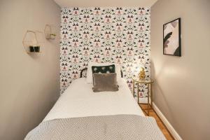 a small bedroom with a bed with a floral wallpaper at Host & Stay - Cobble Cottage in Lindley
