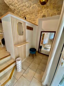a hallway with a mirror and a blue stool at Gîte Thina in Brissac
