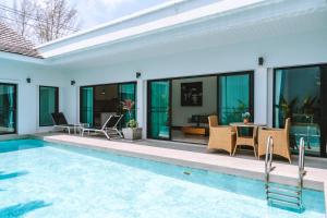 a villa with a swimming pool and a patio at Layantara Resort, Phuket in Layan Beach