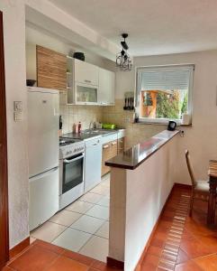a kitchen with white appliances and a window at Holiday Homer Kuća na obali Vrbasa in Banja Luka