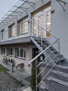uma casa com um corrimão de metal nas escadas em Biłgoraj Aparthotel em Bilgoraj