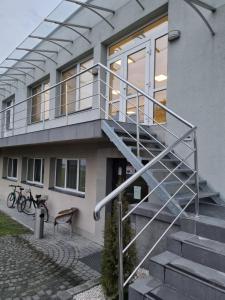 a house with a metal railing on the stairs at Biłgoraj Aparthotel in Biłgoraj