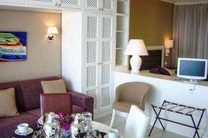 ein Wohnzimmer mit einem Sofa und einem Tisch in der Unterkunft Studio in Villa Oasis Residence in Taormina in Mazzeo