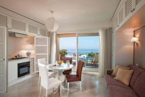 eine Küche und ein Wohnzimmer mit einem Tisch und Stühlen in der Unterkunft Studio in Villa Oasis Residence in Taormina in Mazzeo