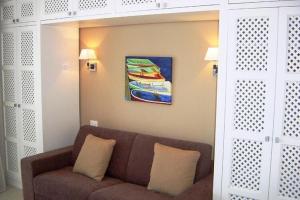 ein Wohnzimmer mit einem Sofa und einem Gemälde an der Wand in der Unterkunft Studio in Villa Oasis Residence in Taormina in Mazzeo