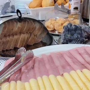 una mesa con jamón y pinzas en un plato en Canoas Hotel, en Três Lagoas