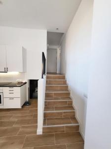 a staircase in a kitchen with white walls and wooden floors at Bonito piso a 300 m de Metro García Noblejas in Madrid