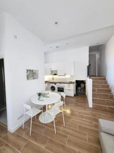 a kitchen and dining room with a white table and chairs at Bonito piso a 300 m de Metro García Noblejas in Madrid
