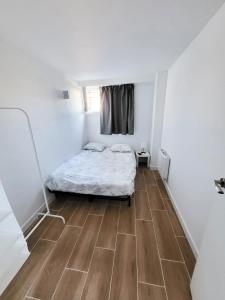 a small bedroom with a bed and a wooden floor at Bonito piso a 300 m de Metro García Noblejas in Madrid