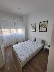 a bedroom with a bed and two pictures on the wall at Bonito piso a 300 m de Metro García Noblejas in Madrid