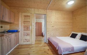 - une chambre avec un lit dans une cabane en bois dans l'établissement Lovely Apartment In Pogorzelica With Kitchen, à Pogorzelica
