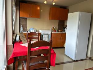 a kitchen with a table and a white refrigerator at Pensiune Daniela in Corbeni