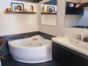 a bathroom with a large tub and two sinks at -Le Carillon- Jacuzzi Suite Privé close to Bergamo in Sorisole