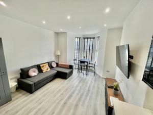 un soggiorno con divano e tavolo di New Modern Apartment With FREE Private Parking a Plymouth
