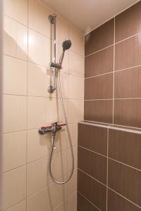 een douche met een douchekop in de badkamer bij Friends & Family Apartment in Trenčín