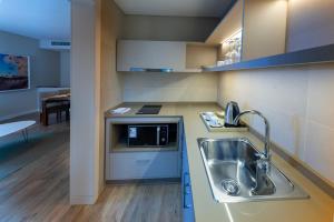 a kitchen with a sink and a microwave at Iguazu Jungle Lodge in Puerto Iguazú