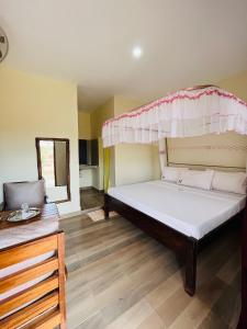 1 dormitorio con 1 cama con dosel en Lake Jipe Eco Lodge, en Tsavo West National Park