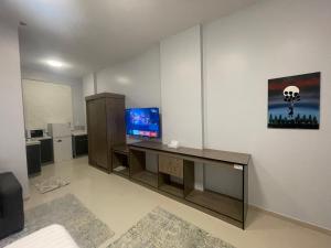 a living room with a desk with a tv at LOTA Suites in Al Baha