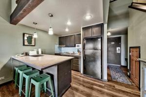 una cocina con una gran isla con taburetes verdes en Newly Remodeled Studio plus Loft- Lakeland Village condo, en South Lake Tahoe