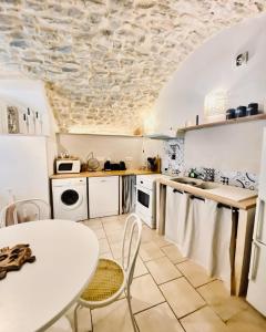 a kitchen with a table and a white counter top at Gîte Thina in Brissac