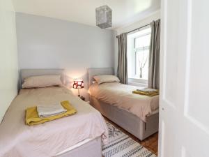 a bedroom with two beds and a window at Windycroft in Barmouth