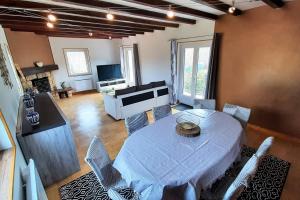 ein Wohnzimmer mit einem weißen Tisch und Stühlen in der Unterkunft Villa Magnolia 8 personnes in Coubon