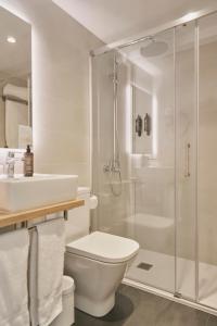 a bathroom with a shower and a toilet and a sink at Tres Torres Atiram Hotels in Barcelona