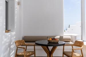 a living room with a table and two chairs at Arotron Santorini in Pirgos