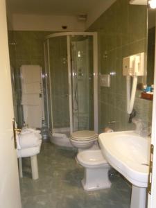 La salle de bains est pourvue de toilettes, d'un lavabo et d'une douche. dans l'établissement Grand Hotel Villa Balbi, à Sestri Levante