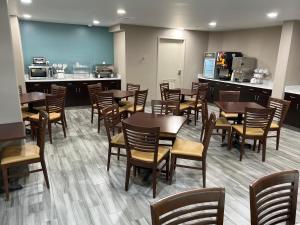 a dining room with tables and chairs and a kitchen at Sleep Inn Northlake in Charlotte