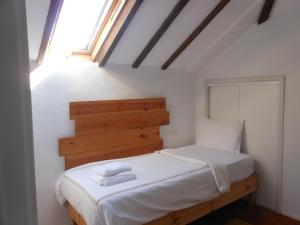 a bedroom with a bed with white sheets and a window at Lisbon Blue House in Oeiras