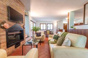 a living room with two couches and a fireplace at Sangiovese - Villetta nella campagna toscana in Abbadia di Montepulciano