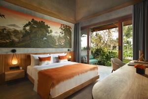 a bedroom with a large bed and a large painting on the wall at Inara Alas Harum in Gianyar