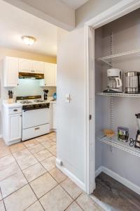 eine Küche mit weißen Schränken und Fliesenboden in der Unterkunft 3BR Home with In-Unit Laundry, Parking, Sound Bar in Rochester