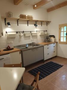 a kitchen with white cabinets and a sink and a table at Sonnenalm in Arnfels