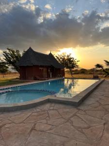Tsavo West National Park的住宿－Lake Jipe Eco Lodge，一个带游泳池和小屋的度假村